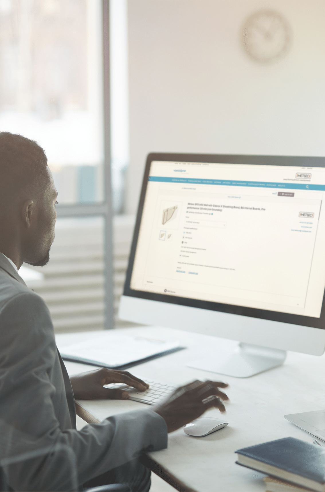 Back view portrait of African-American office worker using computer with black screen while sitting at workplace, shot from behind glass, copy space